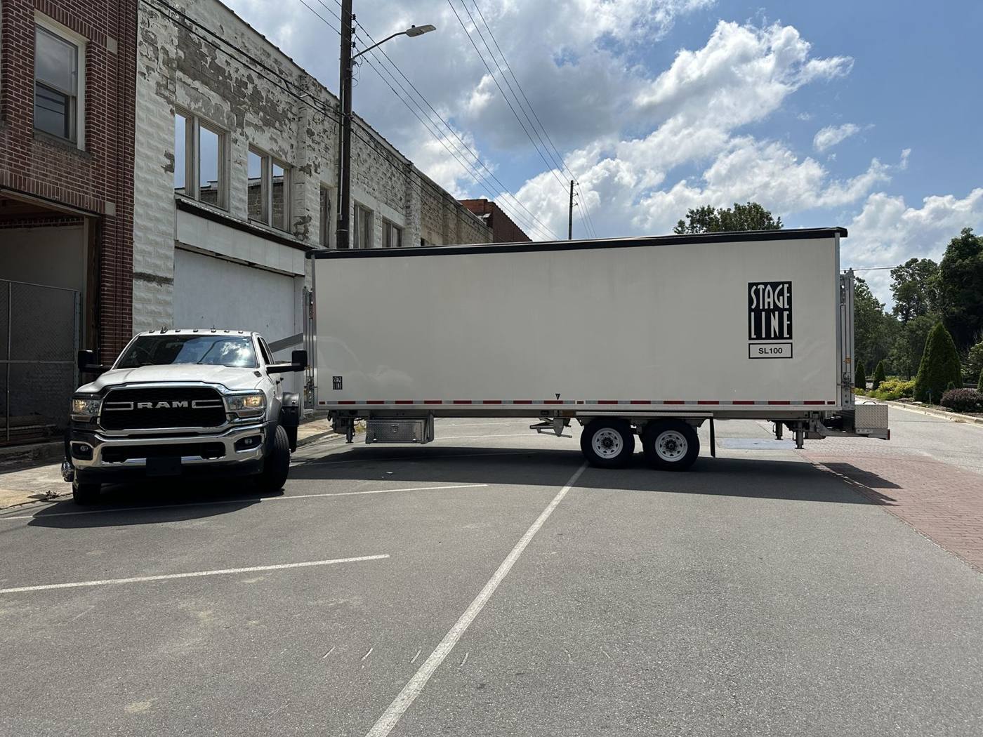 Ram truck towing the SL100 trailer through a downtown street