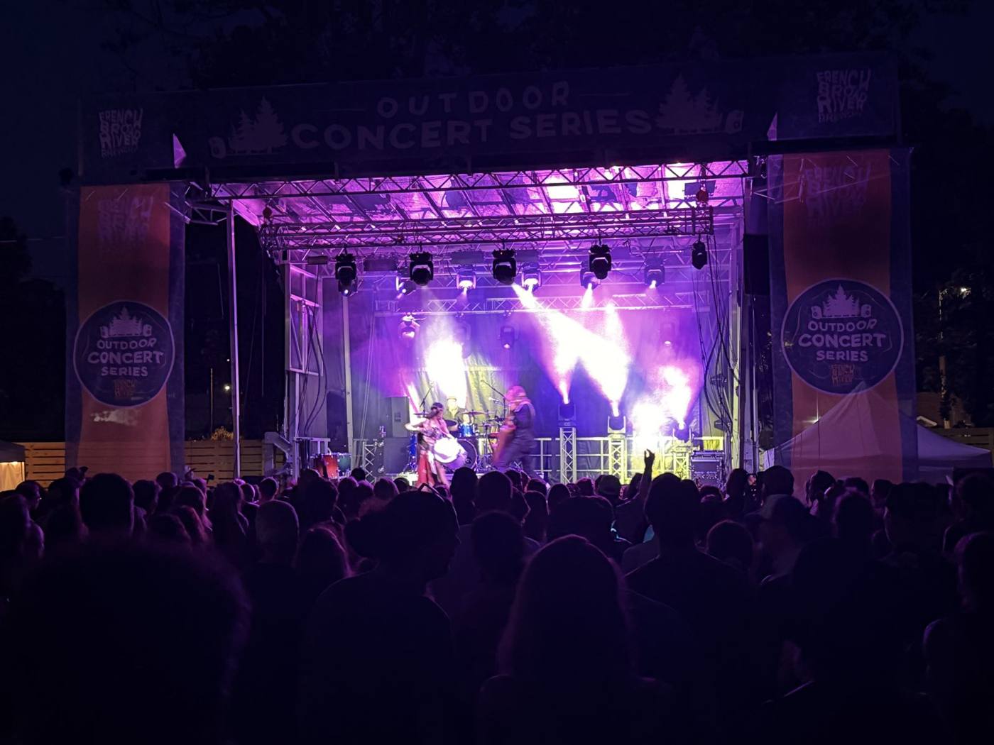 Stage lights over a night crowd at the Outdoor Concert Series