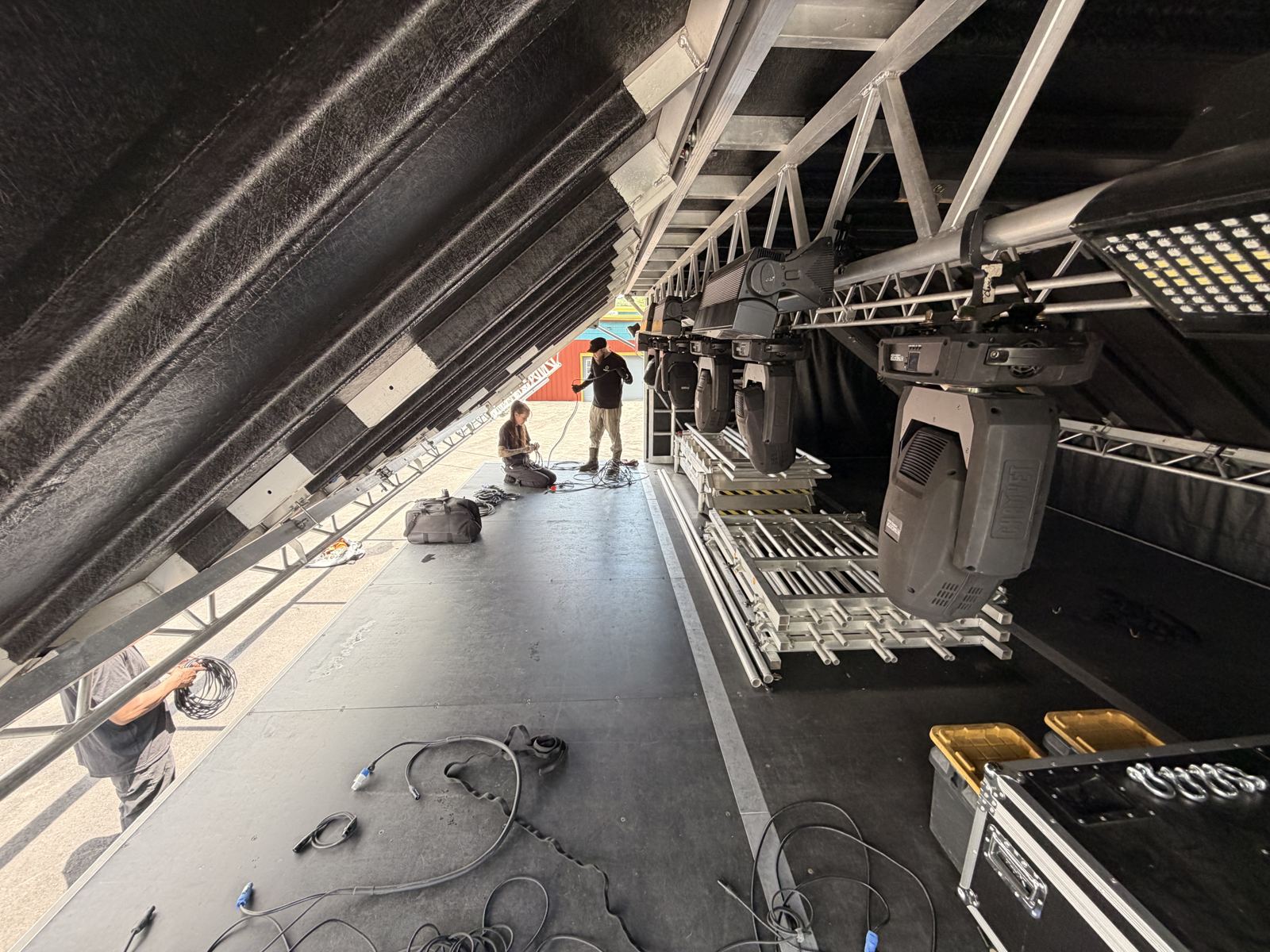 Moving-head lights hanging from the SL100 roof truss over a cleared deck