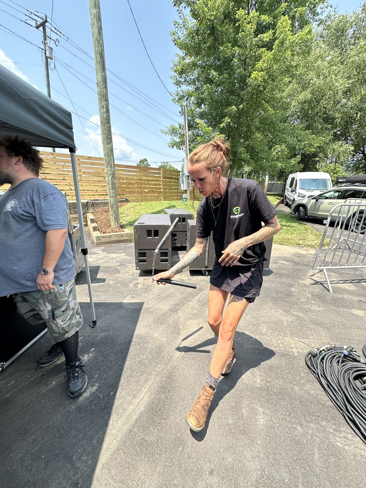 Stagehands moving gear across the SL100 deck during load-in