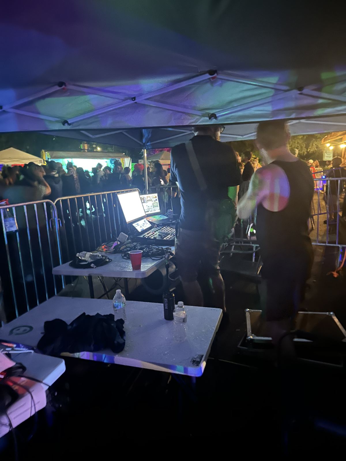 Stagebot crew working front of house under a tent during a night show