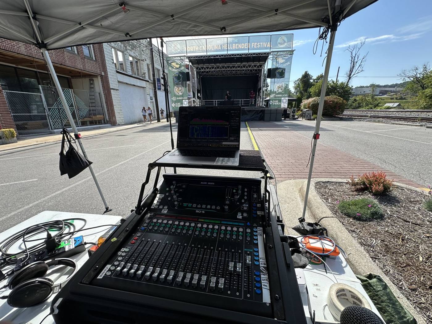 Front-of-house console under a tent on Main Street, stage in the distance